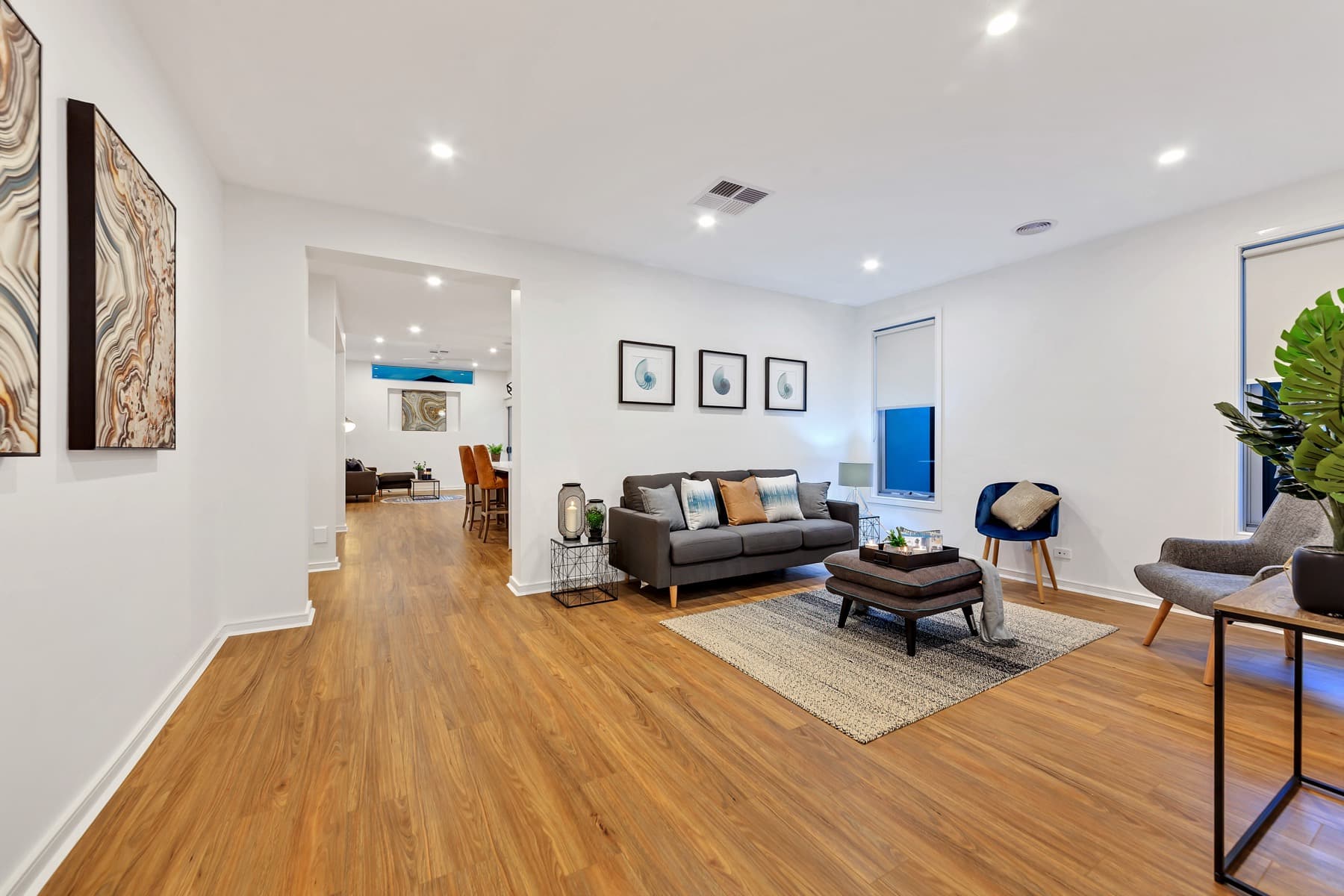The living room of the completed home, timber floor and two sofas