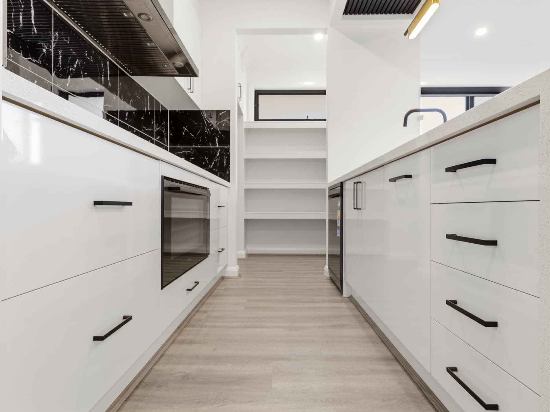 The galley between the kitchen and the pantry shelving