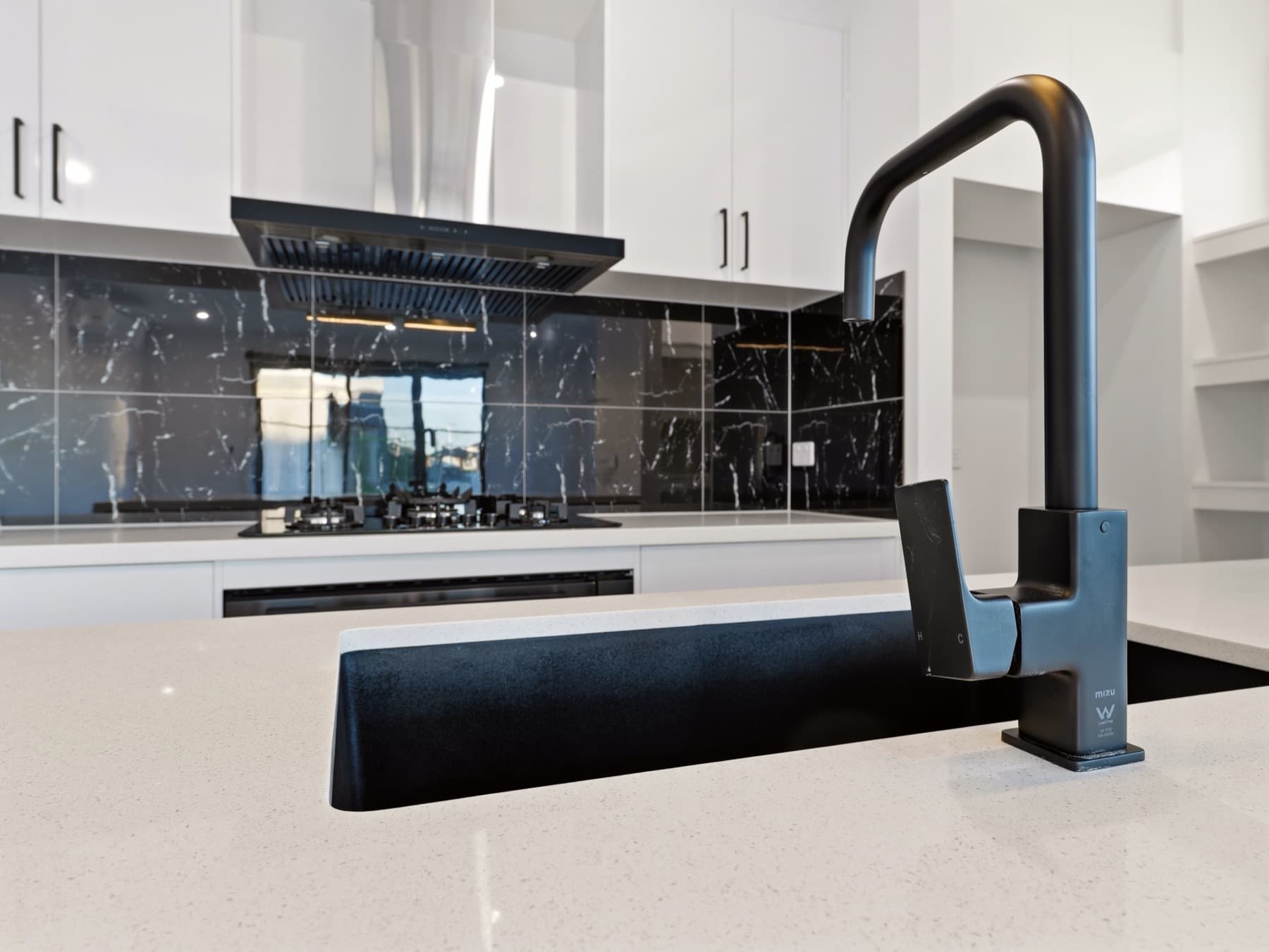 The matte black mixer at the island sink