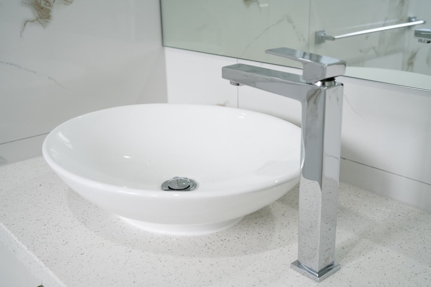 A vessel basin and tall chrome mixer