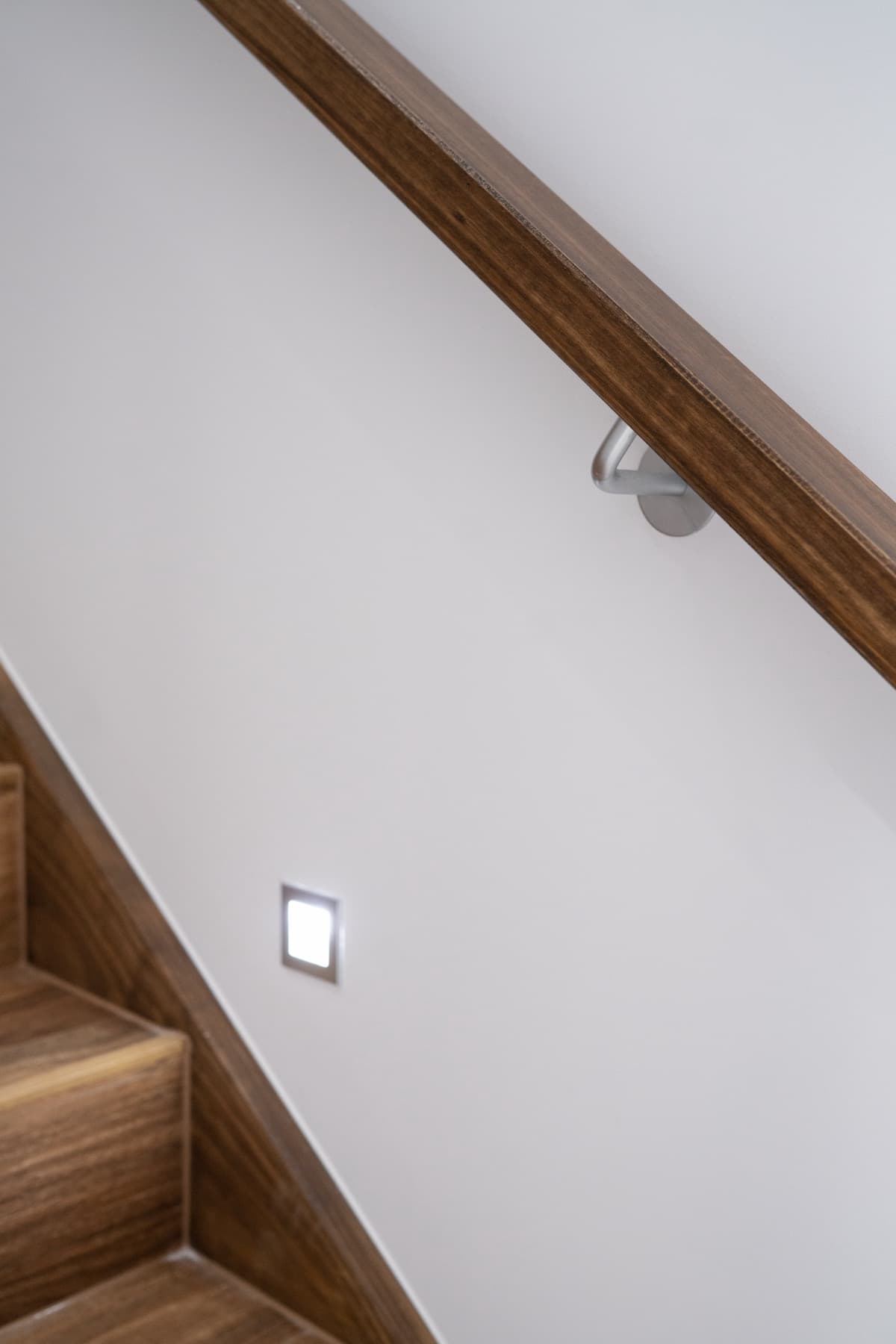 A wall light set into the timber staircase