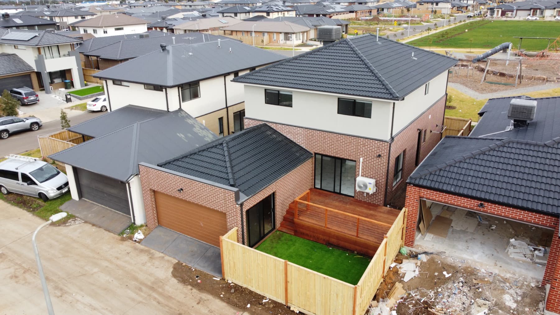The completed two storey home and its street, photographed from the air