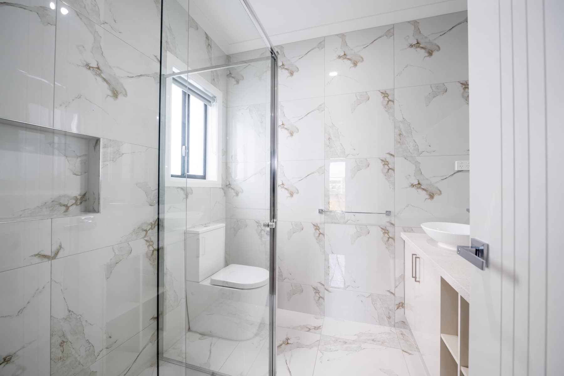 A bathroom tiled in marble look stone