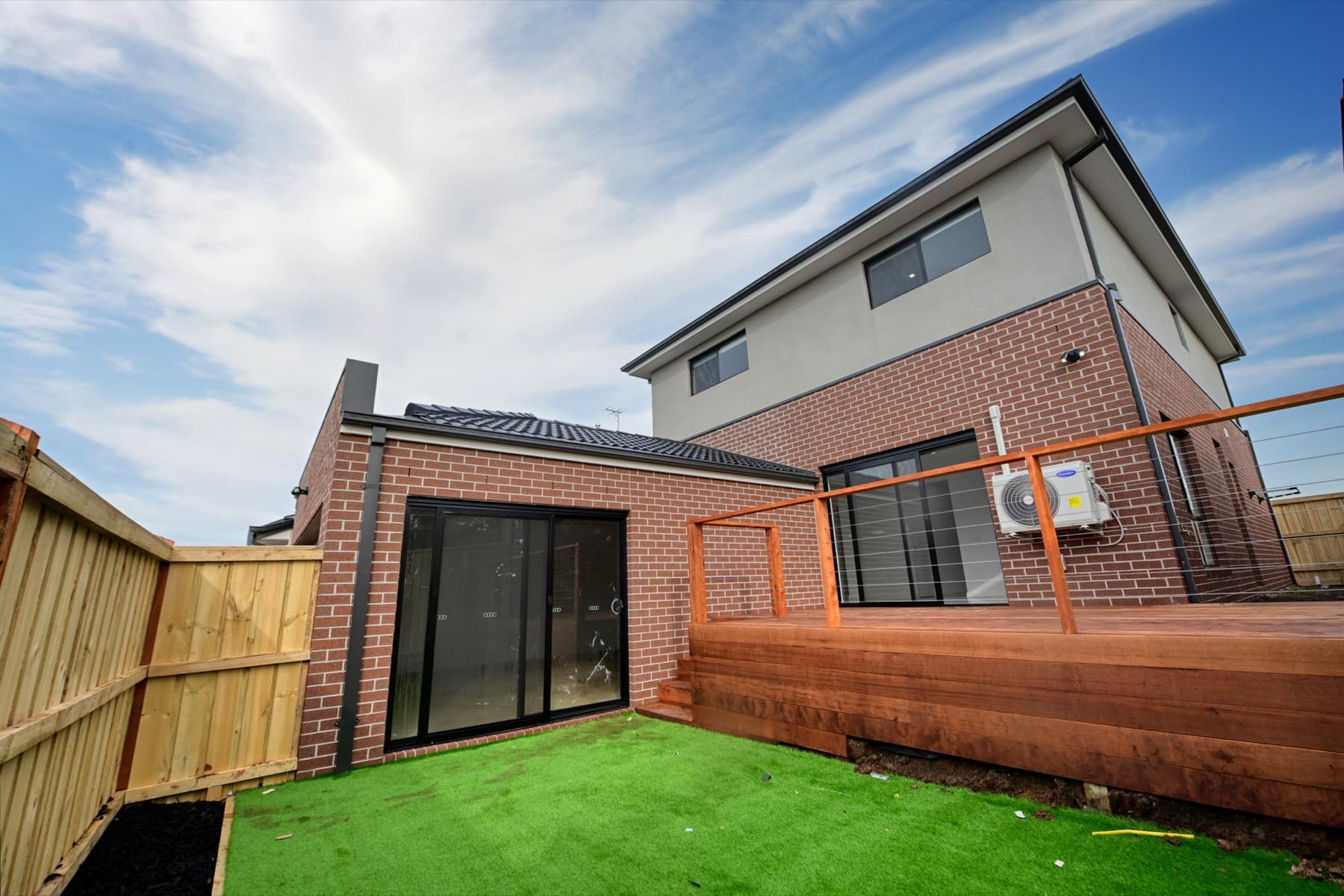 The rear deck and turfed yard of the two storey home