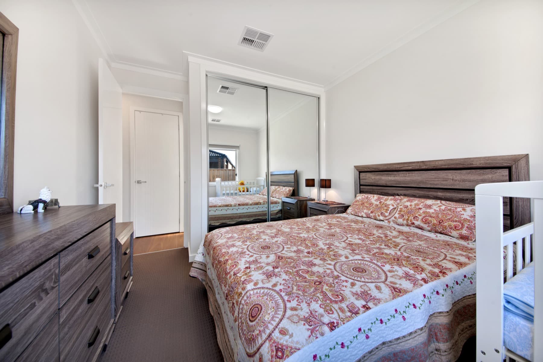 A bedroom with mirrored robes