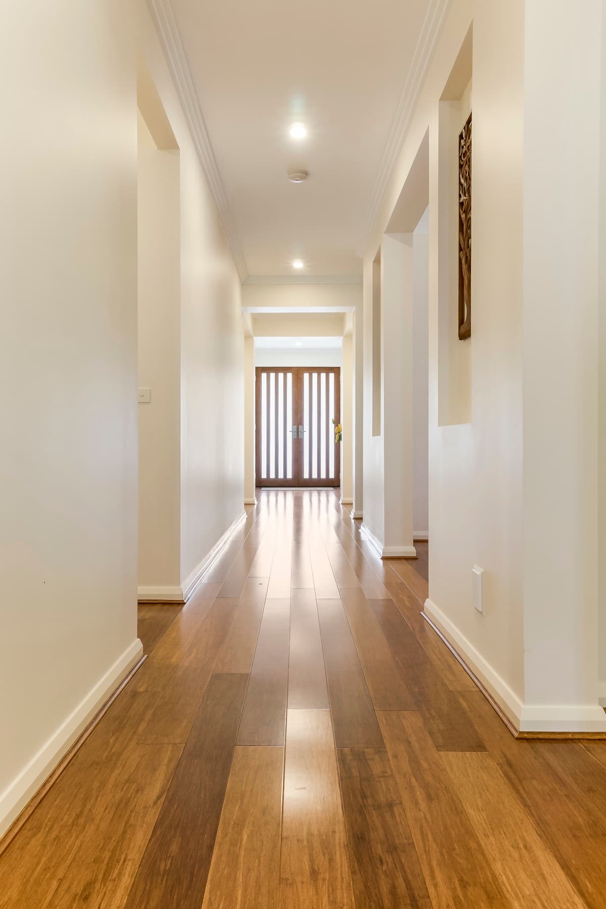 The hallway of a completed Zaman home, timber floor leading to the front door