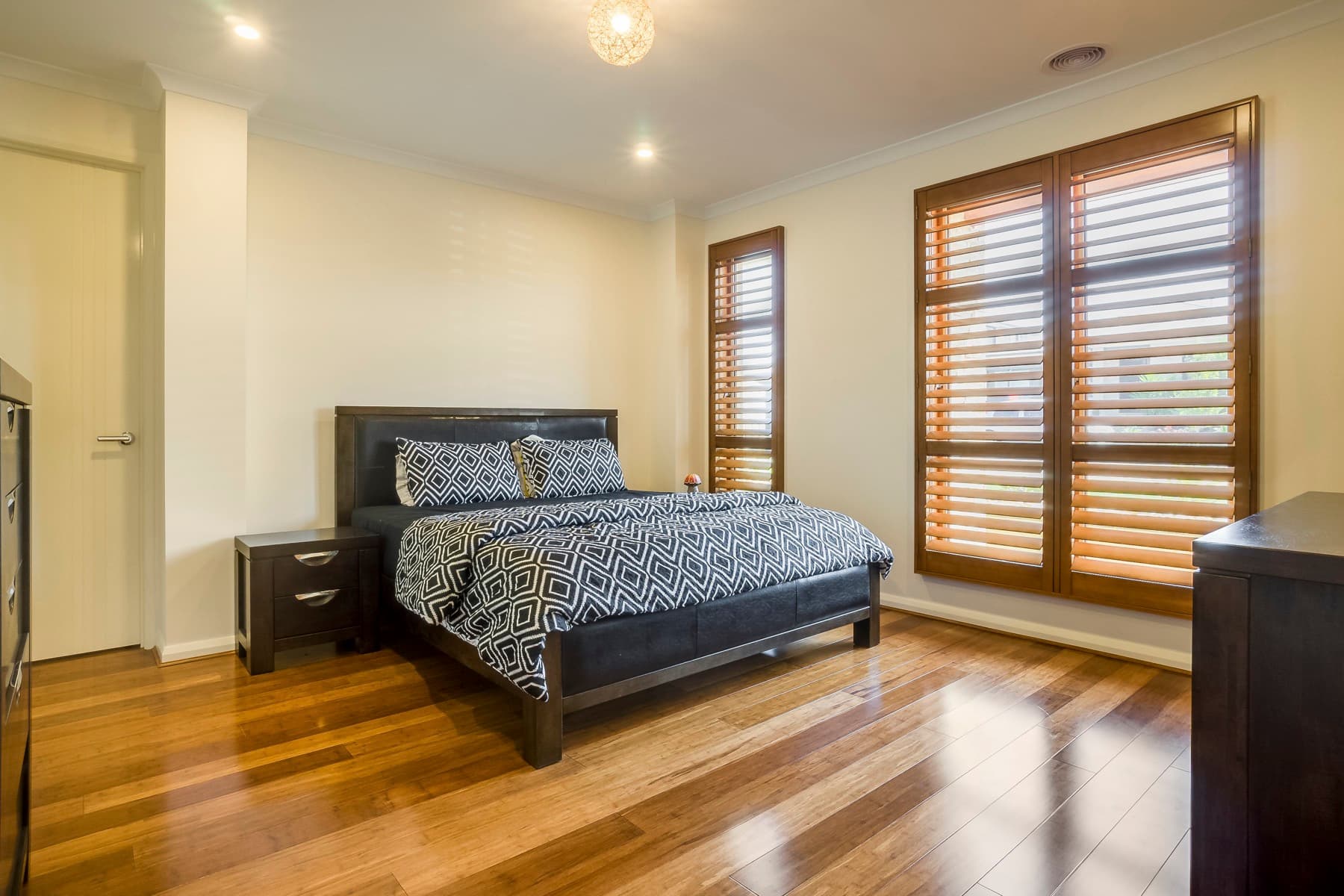 A bedroom behind timber shutters