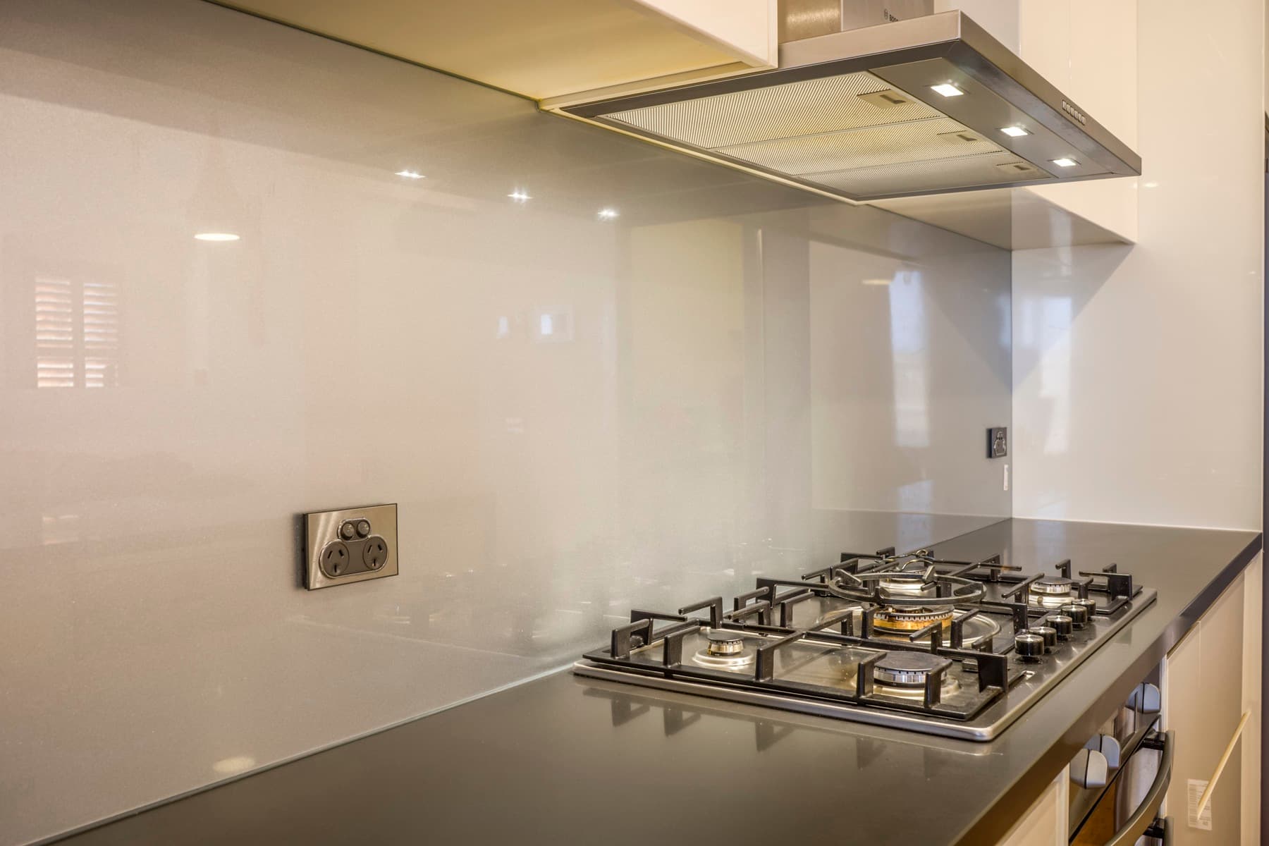 The gas cooktop and its splashback